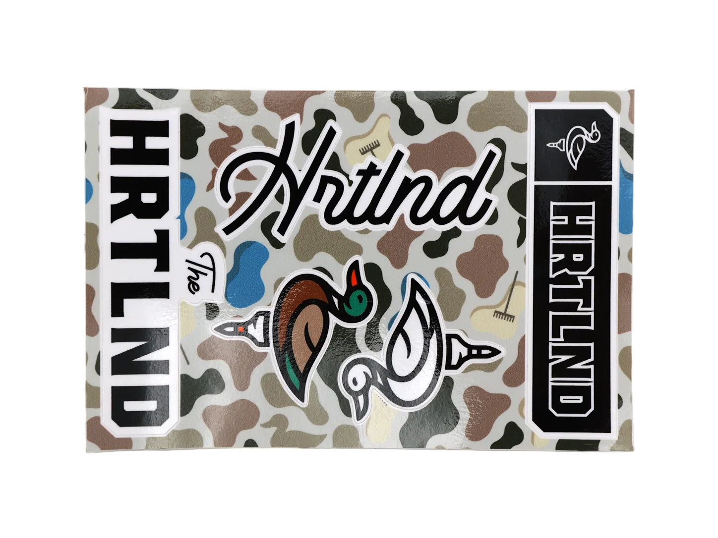 A rectangular HRTLAND branded sticker or decal sheet featuring a woodland camouflage pattern with duck illustrations and bold black-and-white text panels.